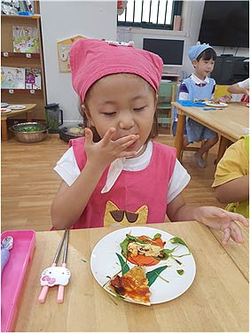 텃밭 채소루꼴라로 만든 요리를 맛보는 어린이