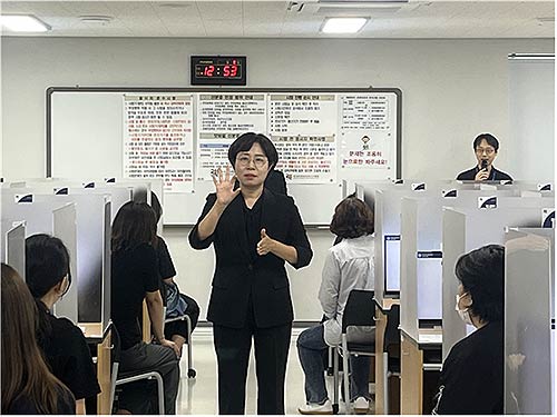 청각장애 응시자들을 위해 수어로 시험 시작 전  응시자 시험요령을 안내하고 있는 모습