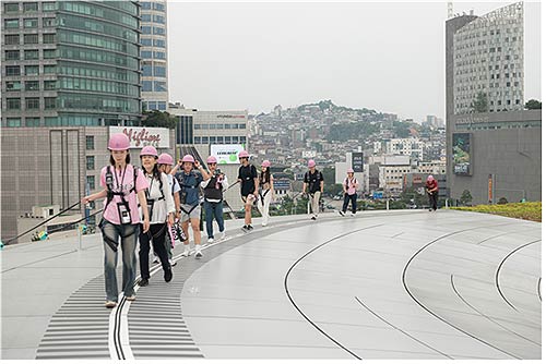 2025년 봄 시범 운영된 DDP 루프탑투어에서 시민들이 곡선 지붕 위를 걷고 있다 