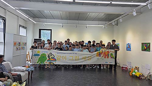 모두의 창작 프로젝트 참가 아동들과 가족들 영은하다 작가가 전시회 현수막 앞에서 기념 촬영을 하고 있다