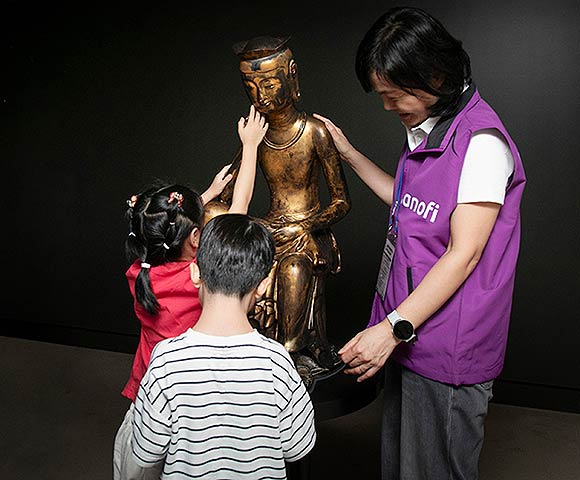 배경은 사노피 한국법인 대표가 국립서울맹학교 학생과 함께 국립중앙박물관 공간 오감 전시를 체험하고 있다